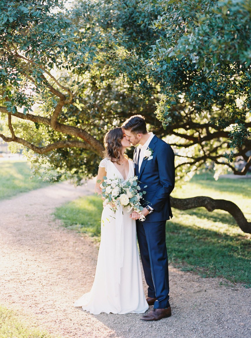 couple kissing under tree - tips for choosing a wedding photographer