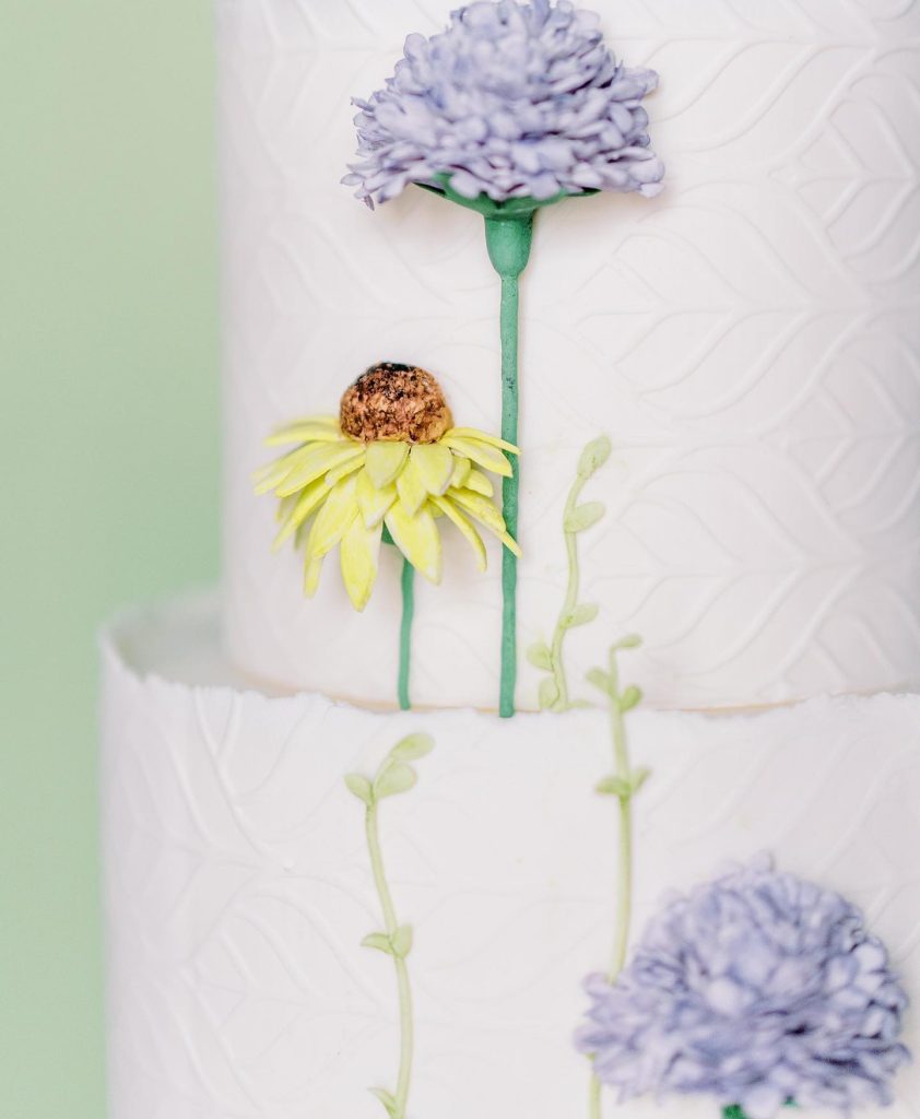 “Textured fondant is on trend so we decided to pair a simple pattern with some whimsical gum paste wildflowers to